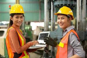 Two female Worker work at factory site check up machine in products line or products in site. Engineer or Technician checking Material or Machine on Plant. Industrial and Factory.