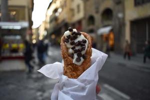 Cannoli with chocolate chips with a soft focus background of Florence, Italy street