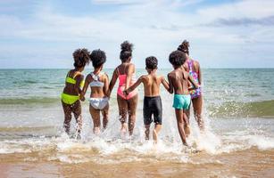 Kids playing running on sand at the beach photo