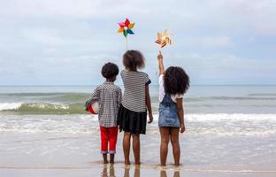 Kids playing running on sand at the beach photo