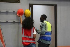 el capataz de los trabajadores de la industria o el trabajo de los trabajadores en el sitio de la fábrica revisan la máquina o los productos en el sitio. ingeniero o técnico revisando material o máquina en planta. industrial y fábrica. foto