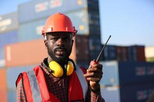 Engineer or supervisor checking and control loading Containers box from Cargo at harbor. Foreman control Industrial Container Cargo freight ship at industry. Transportation and logistic concept. photo