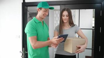 Young man delivered the parcel. Courier with a cardboard box. Parcel Delivery Service. photo