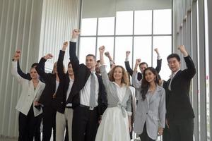 los empresarios exitosos que se unen se ensanchan mostrando una fuerte relación de comunidad de trabajadores. un equipo de hombres de negocios y mujeres de negocios que expresan un sólido trabajo en equipo en la oficina moderna. foto