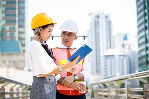 el ingeniero y la gente de negocios chocan los cinco contra la construcción. el concepto de ingeniería, construcción, vida urbana y futuro. foto