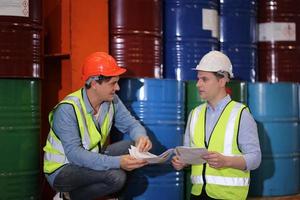 Men industrial engineer wearing a safety helmet while standing in a heavy industrial factory. The Maintenance looking of working at industrial machinery and check security system setup in factory. photo