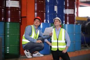 Men industrial engineer wearing a safety helmet while standing in a heavy industrial factory. The Maintenance looking of working at industrial machinery and check security system setup in factory. photo