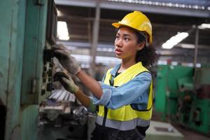 las ingenieras de mantenimiento están trabajando frente a la reparación automatizada de maquinaria cnc en una lista de verificación de mantenimiento en la línea de producción.