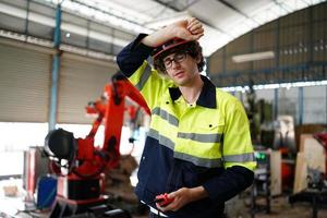 engineer checking control panel and teaching new Automatics robot arm and operating control machine in factory. photo