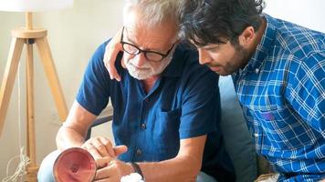 A portrait of adult hipster son and senior father spend time together on weekend at home. photo