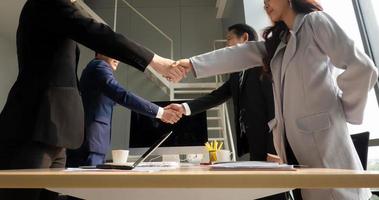 gente de negocios dándose la mano en la oficina moderna terminando una reunión exitosa foto