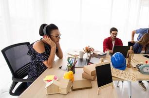 grupo diverso de jóvenes empresarios discutiendo un proyecto de trabajo mientras se sientan juntos en una mesa en una oficina moderna. concepto de coworking foto