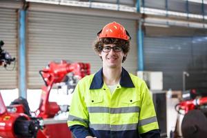 Industrial engineer or worker wearing a helmet while standing in a heavy industrial factory. The Maintenance looking of working at industrial machinery and check security system setup in factory. photo