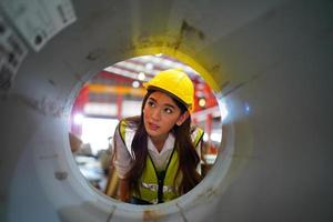 Female worker Foreman or worker work at factory site check up machine or products in site. Engineer or Technician checking Material or Machine on Plant. Industrial and Factory. photo