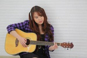 A young beautiful woman plays the guitar. photo