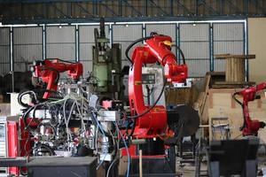 Robotics arm in the metal factory plant . it's performing routine servicing of the welding robotics units equipment. photo