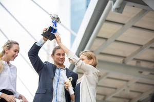 los empresarios exitosos que se unen se ensanchan mostrando una fuerte relación de comunidad de trabajadores. un equipo de hombres de negocios y mujeres de negocios que expresan un sólido trabajo en equipo en la oficina moderna. foto