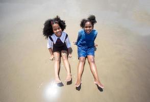 Kids playing running on sand at the beach photo