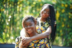 mejores amigos abrazándose, pareja afro girl sonriendo al aire libre. foto