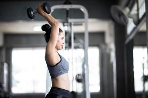 Young woman exercising at the gym. Strong female athlete doing workout. photo