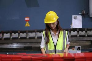 Female worker Foreman or worker work at factory site check up machine or products in site. Engineer or Technician checking Material or Machine on Plant. Industrial and Factory. photo