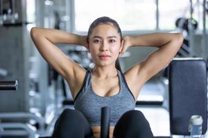 joven mujer asiática entrena y hace ejercicio en el gimnasio. foto