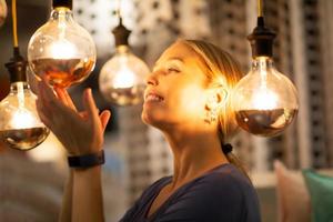 women holding and looking at bulb light reflected on her face photo