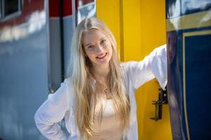 Portrait of a beautiful blonde young woman standing by train. photo