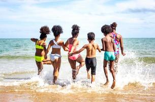 Kids playing running on sand at the beach photo