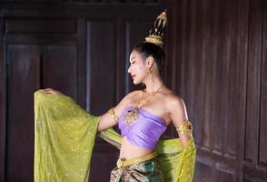 Young Asian women in Traditional dress in the boat and pink lotus flowers in the pond.Beautiful girls in traditional costume.Thai girl in retro Thai dress, Thai girl in traditional dress costume photo