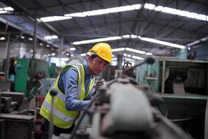 los ingenieros de mantenimiento están trabajando frente a la reparación automatizada de maquinaria cnc en una lista de verificación de mantenimiento en la línea de producción. foto