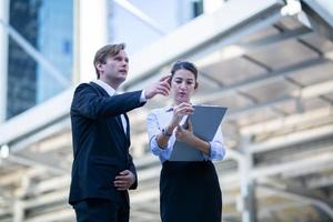 Business people discussing and smiling while walking together outdoor. photo