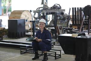 hree Diverse Multicultural Heavy Industry Engineers and Workers in Uniform check automatics robot arm for Factory Using. Female Industrial Contractor is Using a Tablet Computer. photo