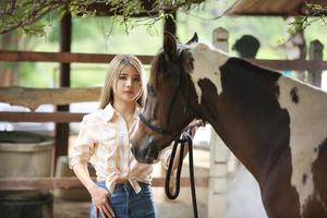 Young woman with her horse in evening sunset light. Outdoor photography with fashion model girl. Lifestyle mood photo