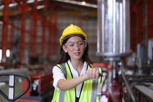 Female worker Foreman or worker work at factory site check up machine or products in site. Engineer or Technician checking Material or Machine on Plant. Industrial and Factory. photo