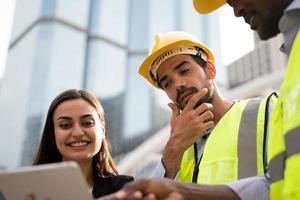 Business woman and Worker discussing with engineer at construction site.
