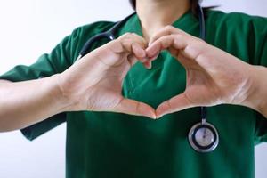 sección media del médico gesticulando mientras está de pie contra la pared foto