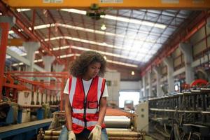 la capataz de la trabajadora o el trabajo del trabajador en el sitio de la fábrica revisan la máquina o los productos en el sitio. ingeniero o técnico revisando material o máquina en planta. industrial y fábrica. foto