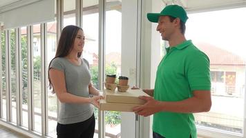 Young man delivered the parcel. Courier with a cardboard box. Parcel Delivery Service. photo