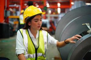 Female worker Foreman or worker work at factory site check up machine or products in site. Engineer or Technician checking Material or Machine on Plant. Industrial and Factory. photo