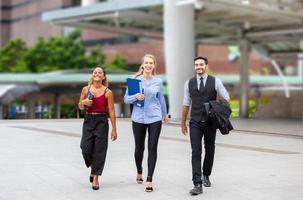 young business people discussing while walking on sidewalk at outside. photo