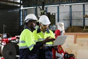 Maintenance Engineers is working in front of the automated CNC machinery repair on a maintenance checklist at the production line. photo