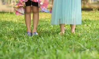 pies de dos niñas sobre hierba en verano. foto