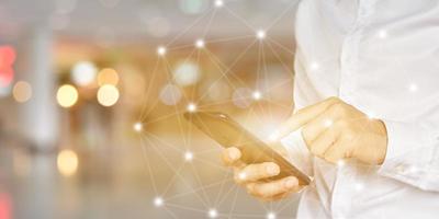 Close up of Businessman using smartphone with icon network. Man hand holding mobile phone for technology or internet banking concept. photo