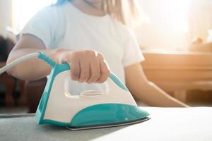 woman ironing clothes on ironing board photo