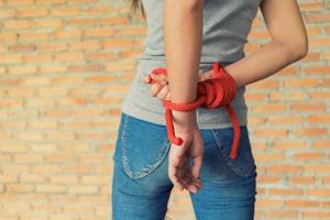 cuerda atada manos de mujer maltratada foto