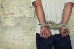 Tied rope hands of abused man photo