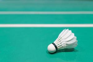 shuttlecock on badminton playing court photo