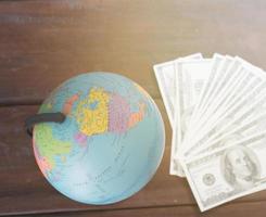 globe with dollar bill on table photo
