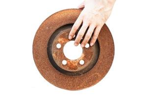 Asian man's hand holding a rusted brake disc photo